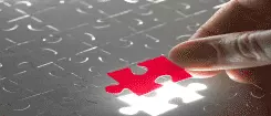 image of red puzzle piece being inserted into a grey puzzle
