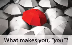 Red umbrella surrounded by white umbrellas.